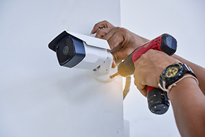 Electrician Fitting CCTV Camera onto wall