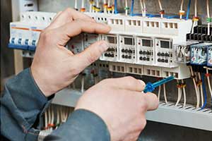 Electrician working on board adhering to electrical safety