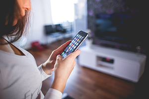 Woman using smart home sensors via her mobile phone