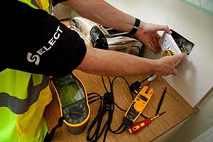A SELECT electrician fitting a plug