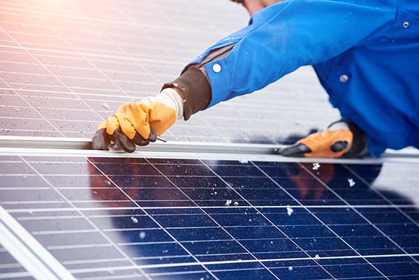 Cropped horizontal shot of a male worker installing solar panels on a power plant using elternative renewable energy copyspace modern technology nature environment concept.