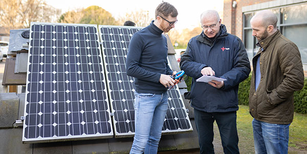 3 gentleman stood in front of solar panels - NICEIC encourages renewable solutions upskilling