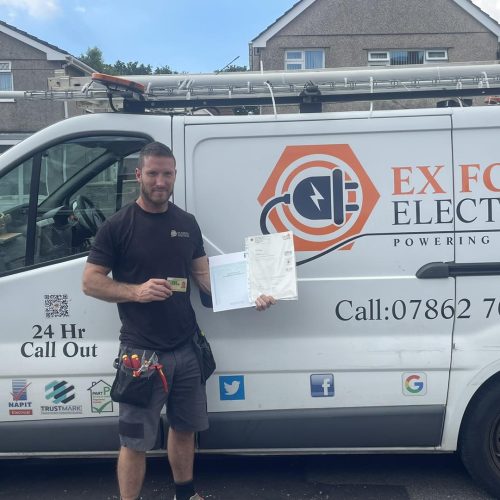 Man stood in front of a van holding his qualification obtained from Electrical Courses Ltd having become an electrician