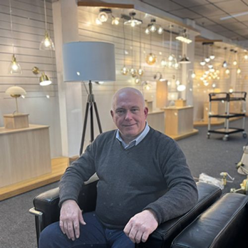 Gary Pearson, New Area Sales Manager at Forum Lighting, instrumental in company growth, and is seated in a lighting showroom on a back leather armchair