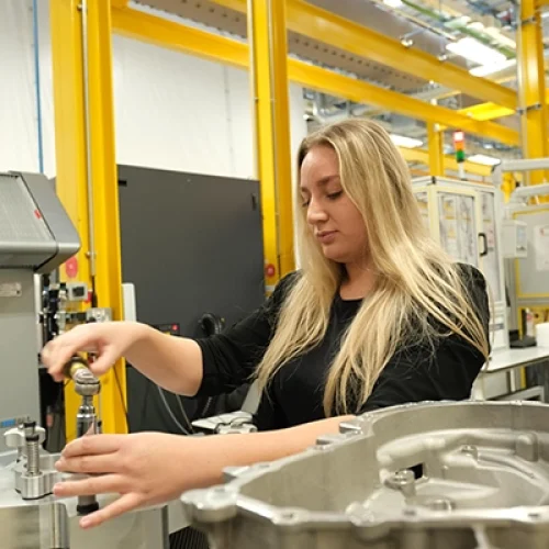 Lady working at a machine in Jaguar Landrover facility - recruitment for 250 electrification engineers