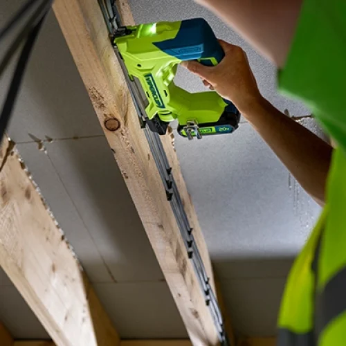 Man using the Viperclip Cable Clip Fasteing System on a wood frame