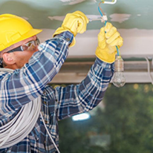 electricians fitting a light