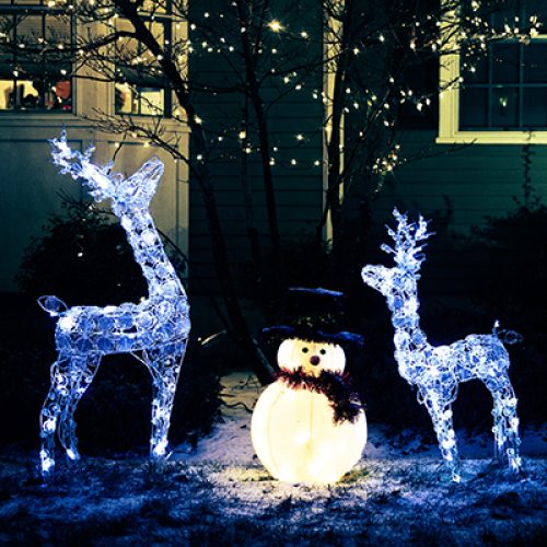 shiny Christmas decorations outside at night. reindeer family and snowman. Christmas background