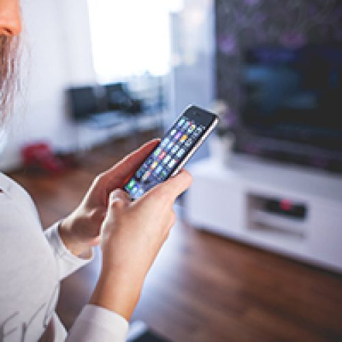 Woman using smart home sensors via her mobile phone