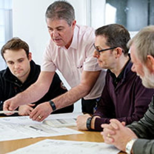 Workers learning about 18th edition on laptops